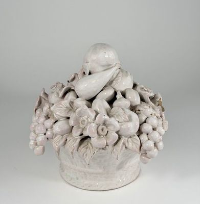 a white vase with a bird and flowers in it