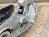 a motor scooter that is parked on the side of the street