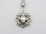 un pendentif en or blanc orné d'un diamant serti au centre