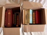 deux cartons contenant des livres, posés sur un lit