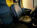 the interior of a car with a black leather seat and a yellow wall