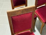four chairs with red upholstered seats on a tile floor
