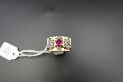 un gros plan d'une bague posée sur une surface noire, avec une étiquette