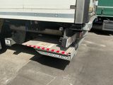 un camion garé sur un terrain avec d'autres camions à l'arrière-plan