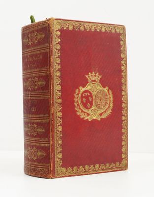 un livre rouge aux bords dorés, surmonté d'une couronne
