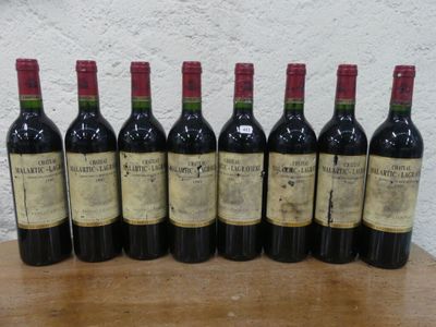 six bouteilles de vin sont alignées sur une table en bois