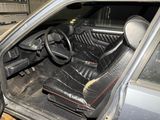 the interior of a car with a black leather seat and steering wheel