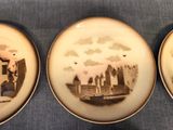 three plates with a picture of a castle on them sitting on a table