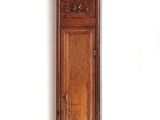 a wooden grandfather clock hanging on the wall next to a white wall