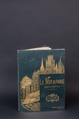 un vieux livre posé sur une table à côté d'une tasse