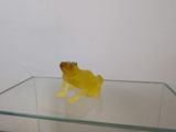 a yellow frog sitting on top of a glass table