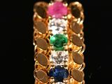 a close up of a gold plated pendant with multi colored stones