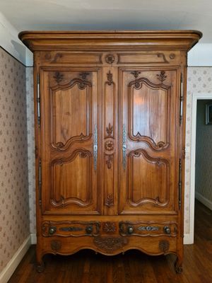 une grande armoire en bois dans le coin d'une pièce