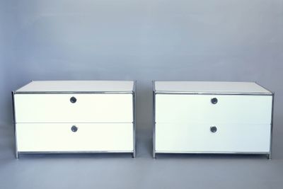 deux commodes blanches, flanquées de tiroirs de chaque côté, sur un fond gris