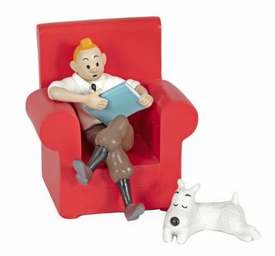 a figurine of a man sitting in a chair with a dog next to him