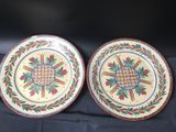 two plates with designs on them are sitting on a table