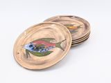 four plates with fish designs on them on a white surface