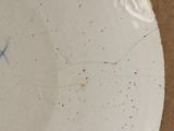 a white plate with blue writing on it on a table
