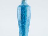 a blue vase that is sitting on a white surface