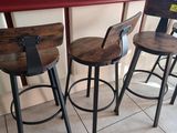 three wooden stools sitting on top of a tiled floor next to a counter
