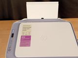 an hp printer sitting on top of a wooden table next to a white box