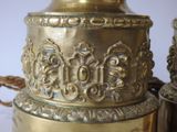 a gold vase sitting on top of a table next to other vases