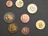 several different coins are arranged on a black surface