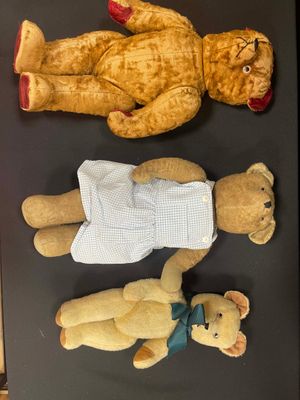 three teddy bears that are laying on a table