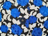 a close up of a woman ' s shirt with blue and white flowers on it