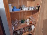 une vitrine en bois sur laquelle sont disposés de nombreux objets en verre