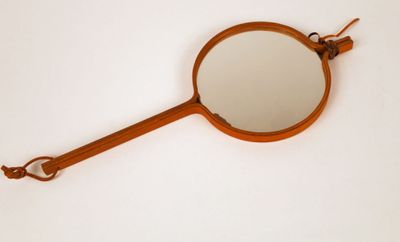 a small mirror hanging on a wall with a hook