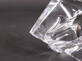a clear glass vase with a bird on it on a table