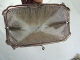 a person holding a metal mesh bag with a handle
