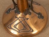 a bronze vase with a design on it on a table