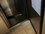 someone is opening the door of a stainless steel refrigerator in a kitchen
