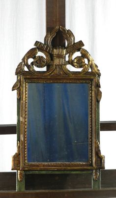 un miroir posé sur une étagère devant une fenêtre