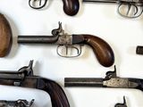 many different types of guns displayed on a white surface