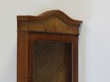 a wooden cabinet with a glass door in the corner