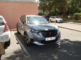 une voiture argentée garée dans un parking à côté d'un bâtiment