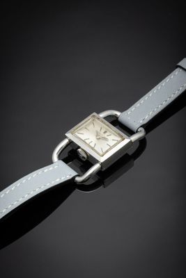 a close up of a silver watch with a leather strap