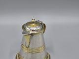 a silver and gold teapot on a white background
