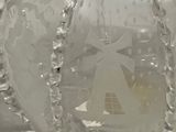 a glass vase with a design on it on a table