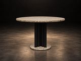 une table à manger ronde avec un piètement noir et un plateau en marbre blanc
