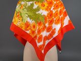 an orange and white floral print scarf on a mannequin head