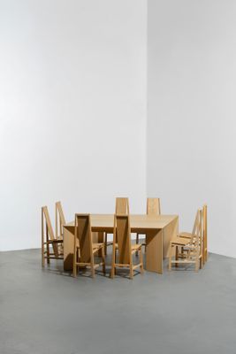 une table et des chaises dans une pièce aux murs blancs