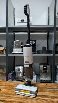 a vacuum that is sitting on a table in front of a shelf