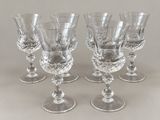 four clear wine glasses sitting on top of a table next to each other
