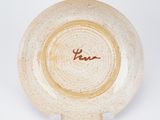 a close up of a white plate with a brown inscription on it