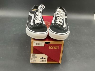 pair of black and white vans sneakers sitting on top of a box