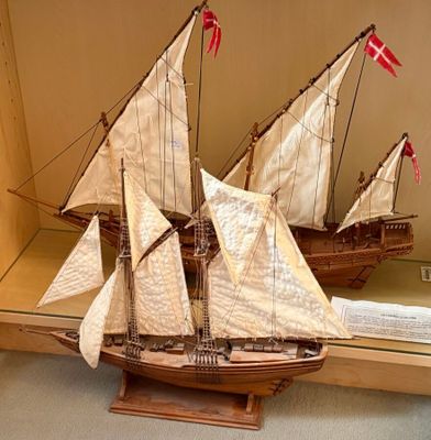 a model of a sailboat on display in a glass case